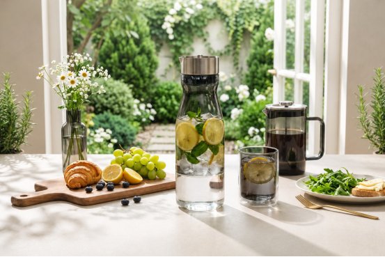 Colored glass kitchenware arranged with storage jars and drinkware in a modern kitchen